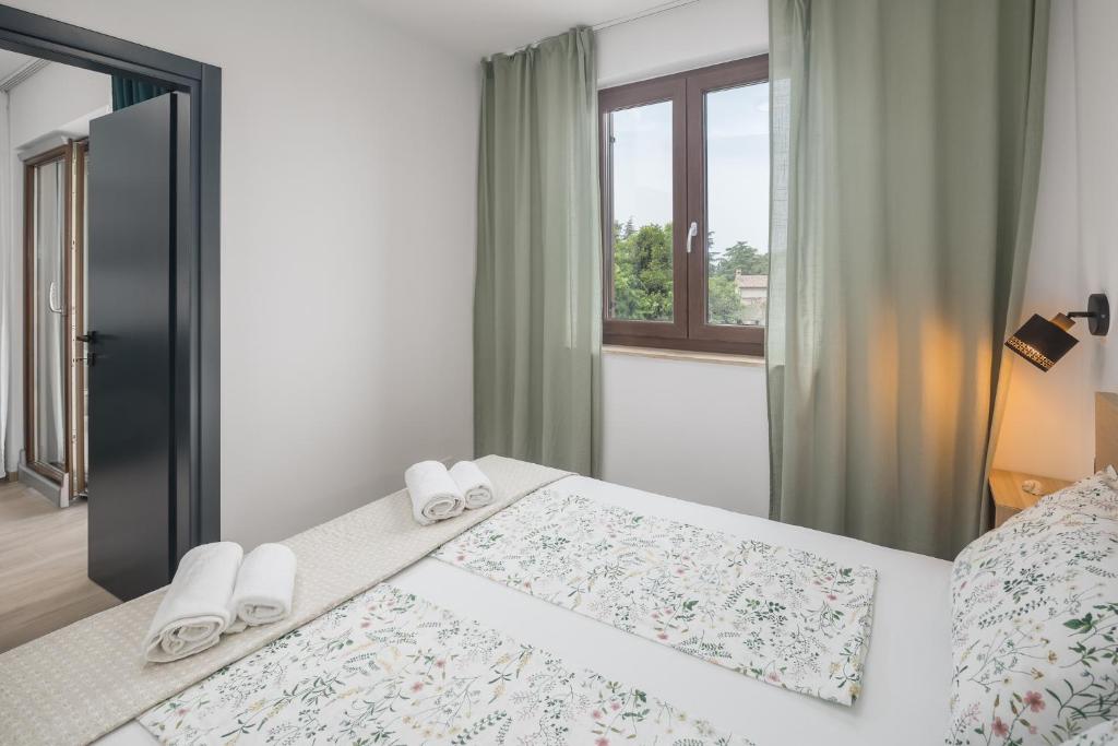 a bedroom with a bed with white towels on it at Apartments Špadići in Poreč
