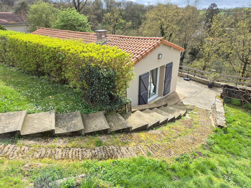 une petite maison avec un escalier en pierre dans une cour dans l'établissement La Terrasse de Rochard Maison 6p proche Puy du Fou, à Mortagne-sur-Sèvre