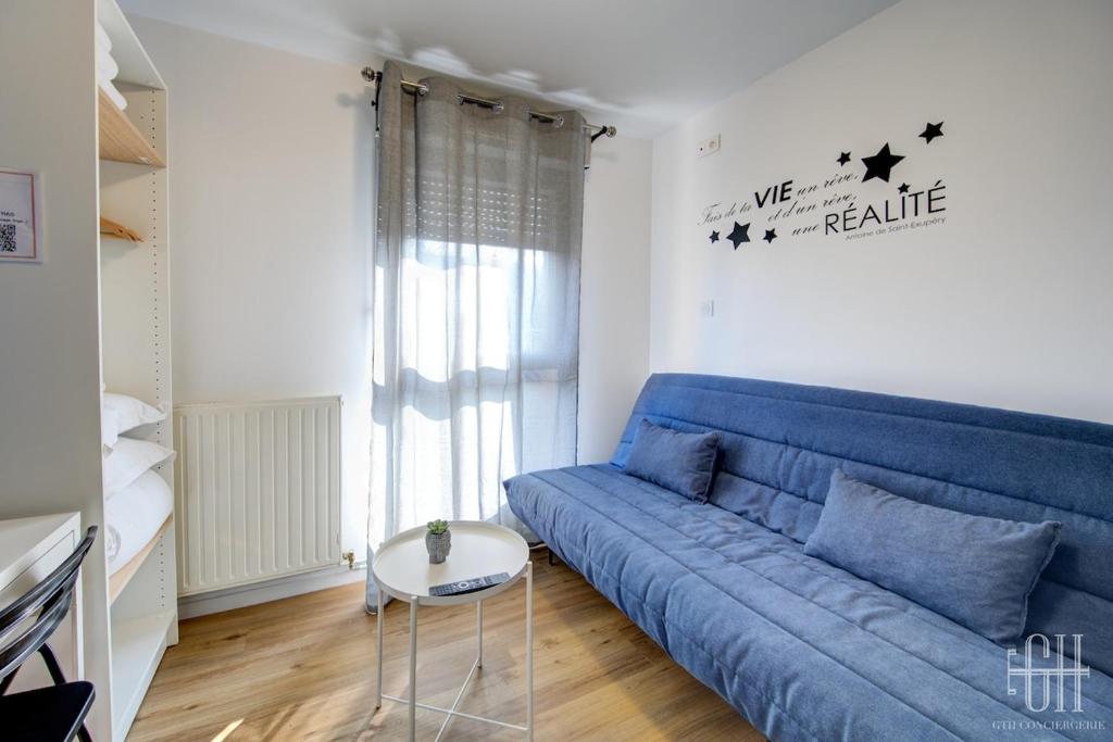 un canapé bleu dans un salon avec une table dans l'établissement Terre - Proche A 10 - 2V - Parking, à Saint-Pierre-des-Corps