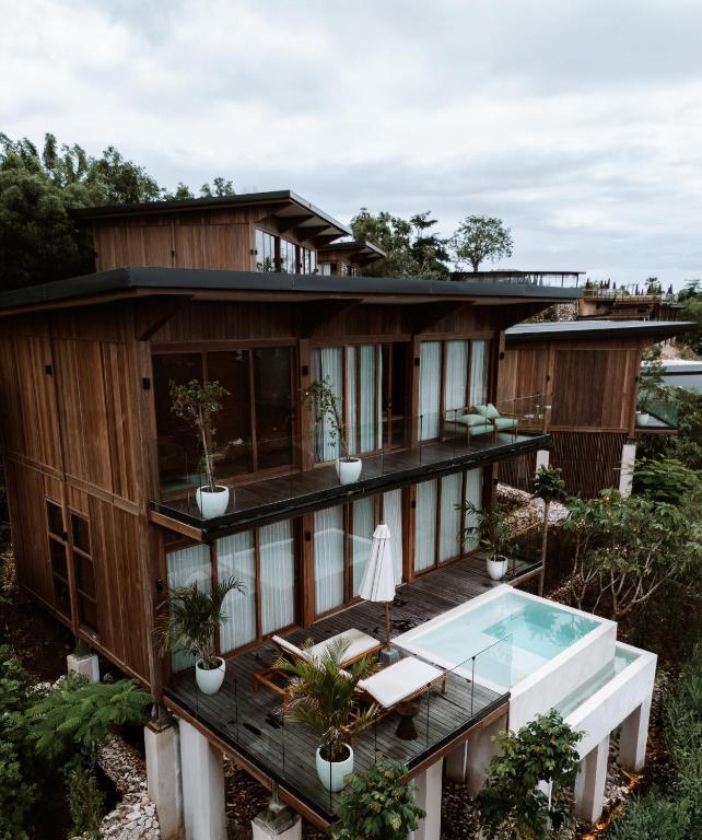 a house with a deck and a swimming pool at Grün Resort Uluwatu in Uluwatu