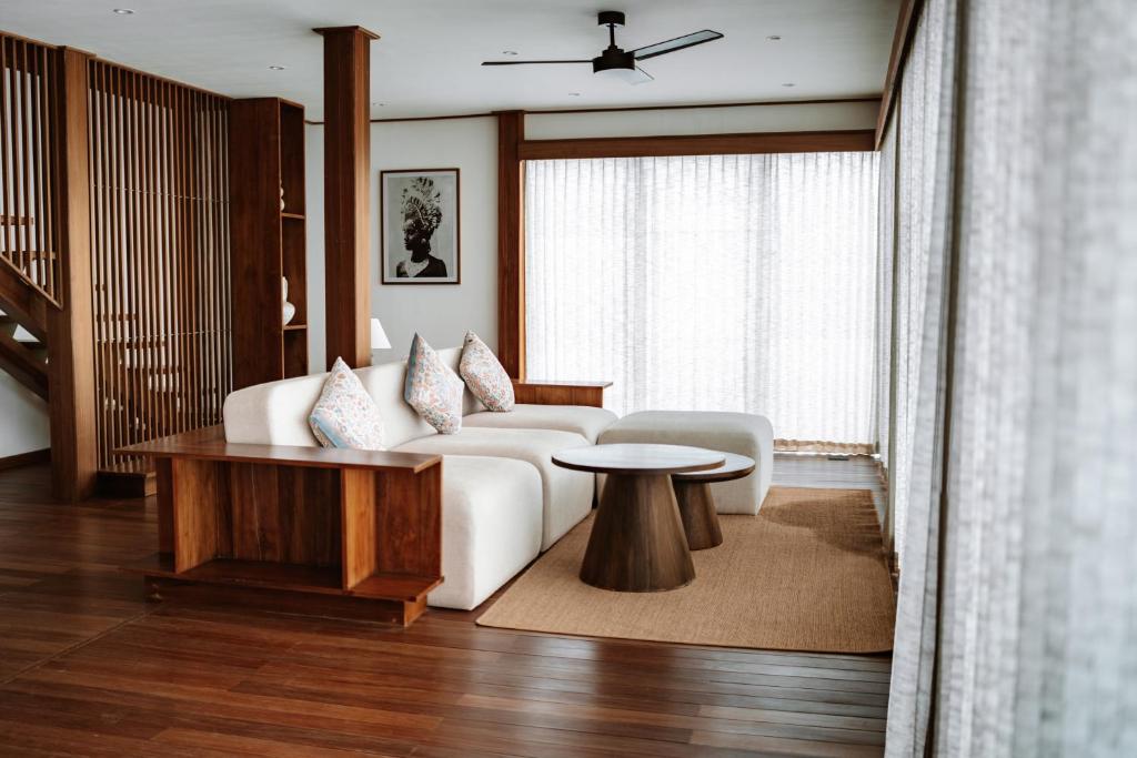 a living room with a white couch and a table at Grün Resort Uluwatu in Uluwatu