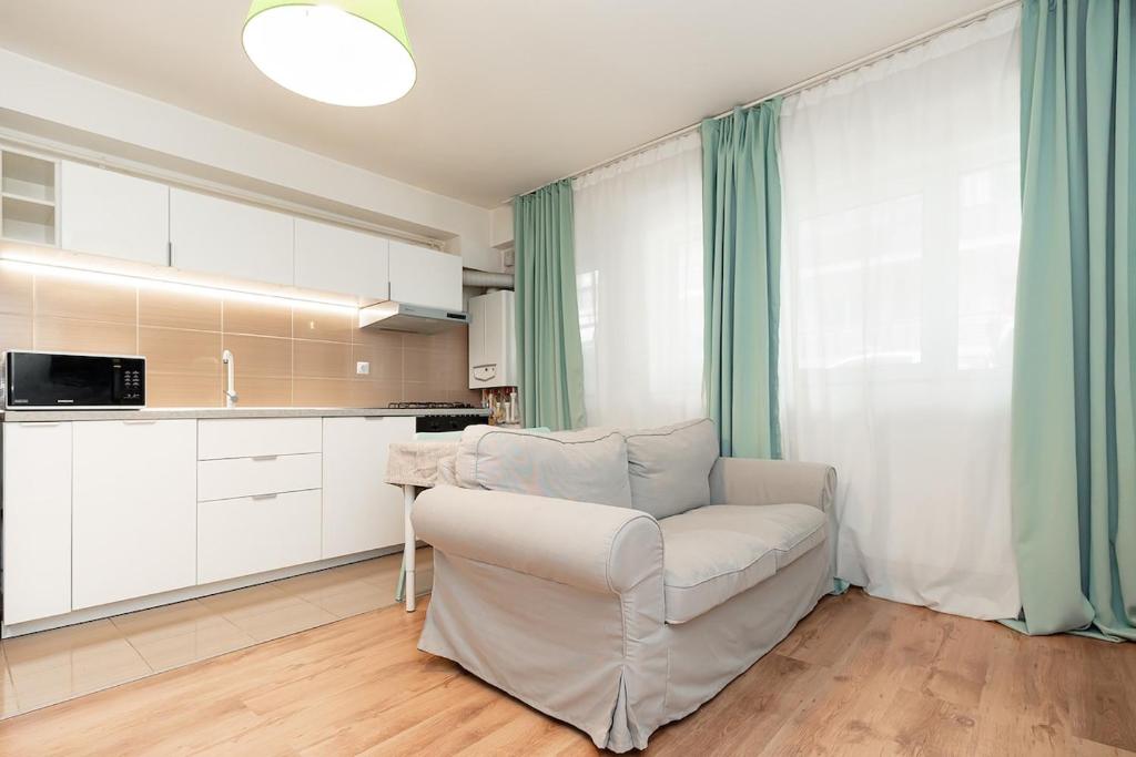 un salon avec un canapé blanc et une cuisine dans l'établissement The Shiny Apple, à Dobroeşti