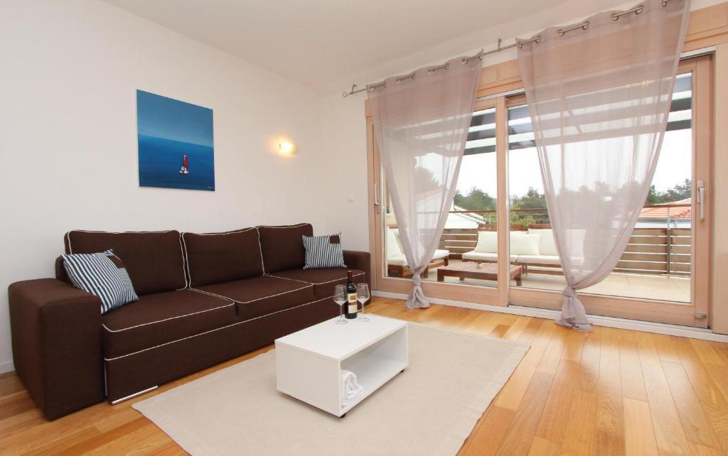 sala de estar con sofá marrón y mesa en Apartments Makado, en Rovinj