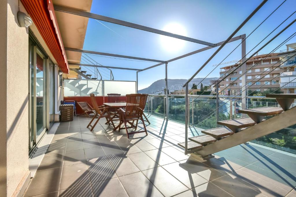 a balcony with a table and chairs on a building at Homeincalpe Borumbot in Calpe
