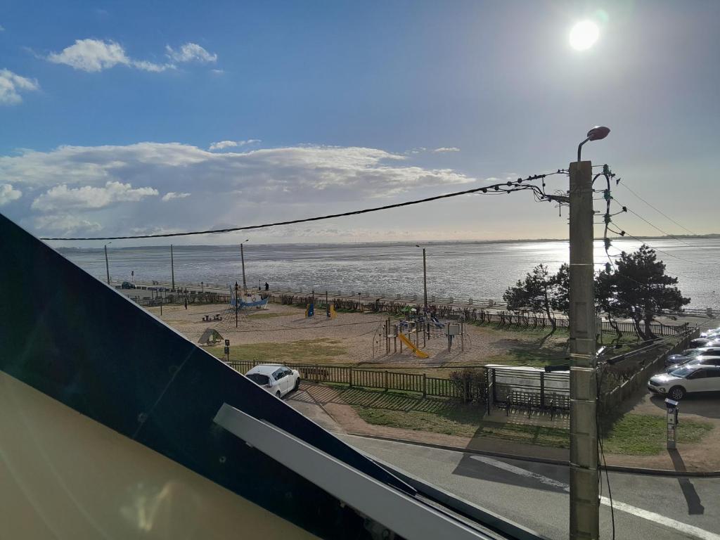 - une vue sur une aire de jeux à côté de l'océan dans l'établissement Appartement vue sur la Baie de Somme - Magnifique terrasse, au Crotoy
