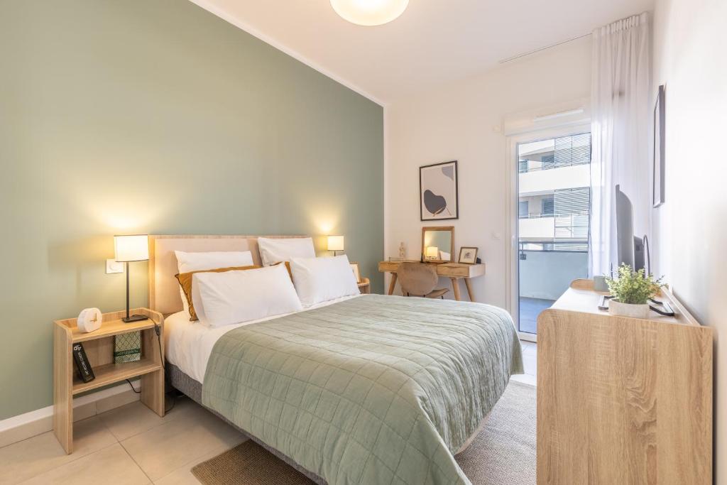 Un dormitorio con una cama grande y una ventana. en Zenao Appart'hôtels Villeneuve Loubet, en Villeneuve-Loubet