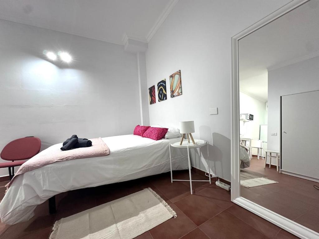 a white bedroom with a bed and a mirror at El Rincón de Pancho in Guía de Isora