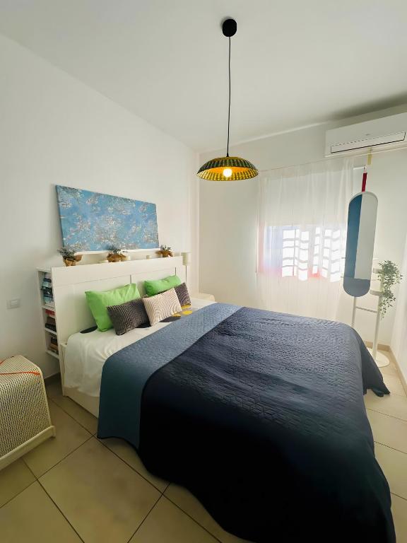 sypialnia z dużym łóżkiem i niebieskim kocem w obiekcie Bungalow Aloe Dunas 2 w mieście Maspalomas