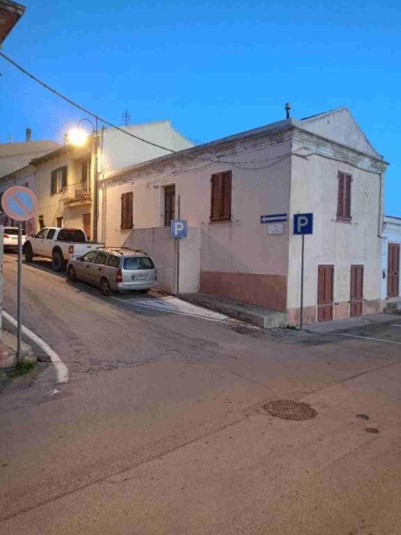 an empty street with cars parked in front of a building at Casa dei bagnanti sul Porto Vecchio in Stintino