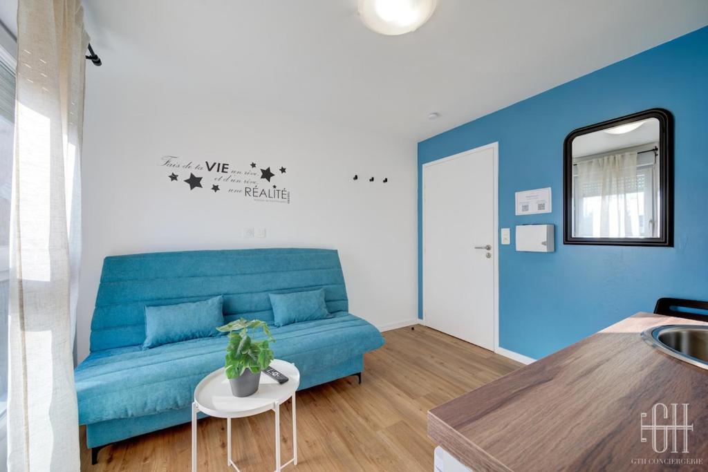 un salon avec un canapé bleu et une table dans l'établissement Uranus - Proche A10 - 2V - Parking, à Saint-Pierre-des-Corps