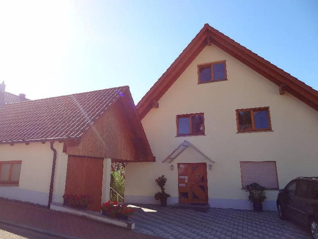 een groot wit huis met een rood dak bij Ferienwohnung Bohnert in Fischerbach