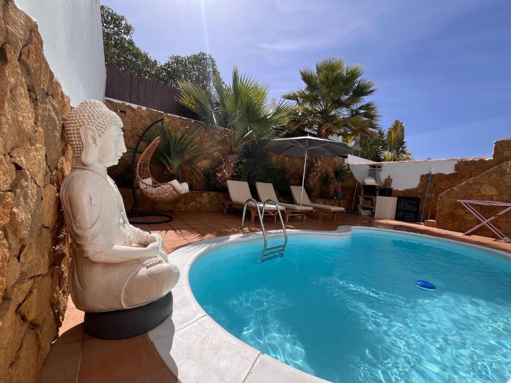 een standbeeld naast een zwembad bij Villa Casa Senna in Corralejo