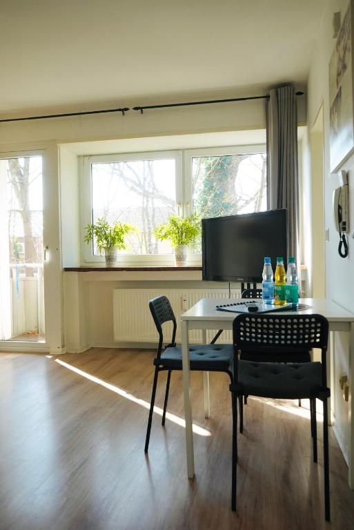 a dining room with a table and chairs and windows at Apartment in ruhiger Lage-Waschmaschine-Balkon in Wolfsburg