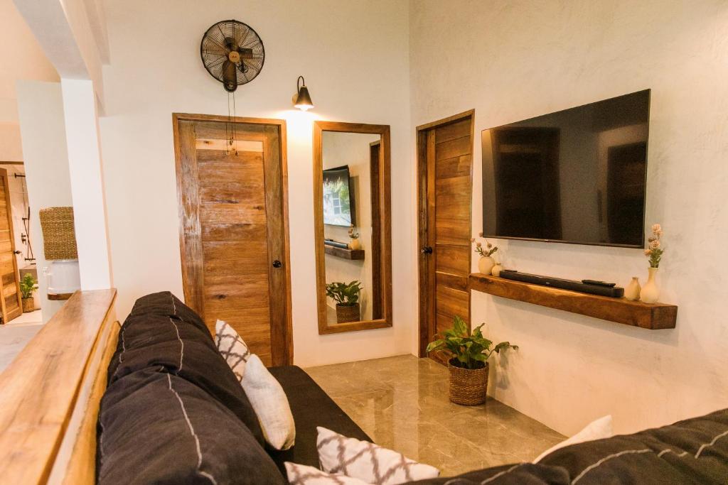 a living room with a couch and a tv at Casa Malia Siargao in General Luna