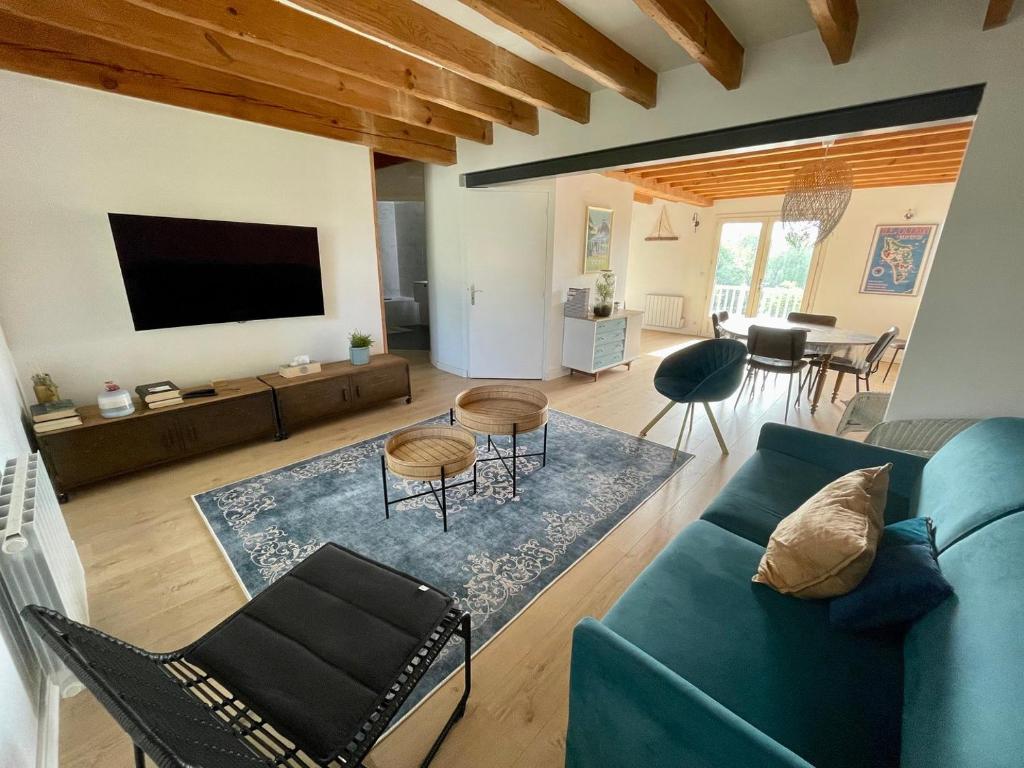 un salon avec un canapé bleu et des chaises dans l'établissement Appartement Arcachon St Ferdinand, à Arcachon