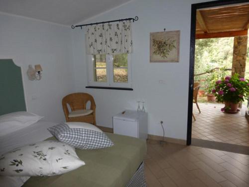 a room with a bed and a table and a window at Agriturismo Palmero in Alassio