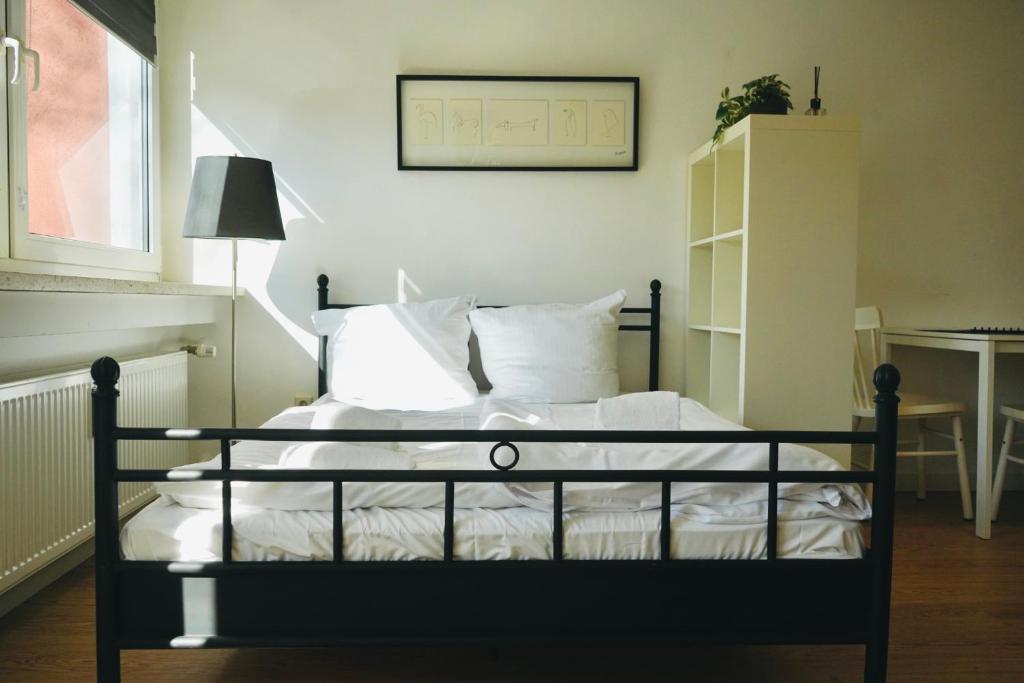 a bedroom with a bed with white sheets and pillows at Kompaktes Apartment in ruhiger Lage in Wolfsburg