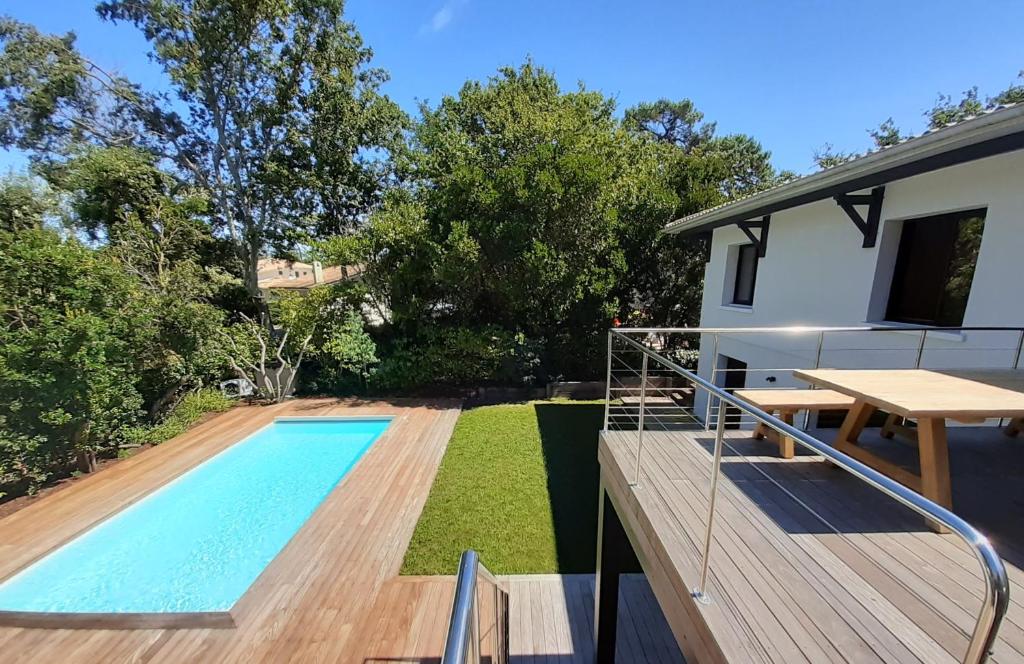 une cour arrière avec une piscine et une maison dans l'établissement Belle Villa moderne 6 chambres et piscine chauffée- au Moulleau, à Arcachon