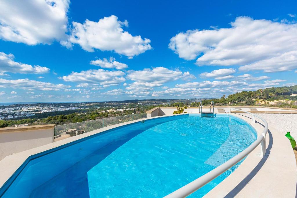 une piscine avec un ciel bleu et des nuages dans l'établissement Villa Horus by Perle di Puglia, à Leuca