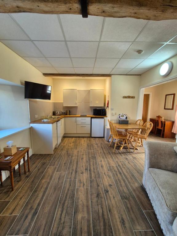 Una sala de estar con un sofá y una mesa y una cocina. en Padley Farm, en Bradfield