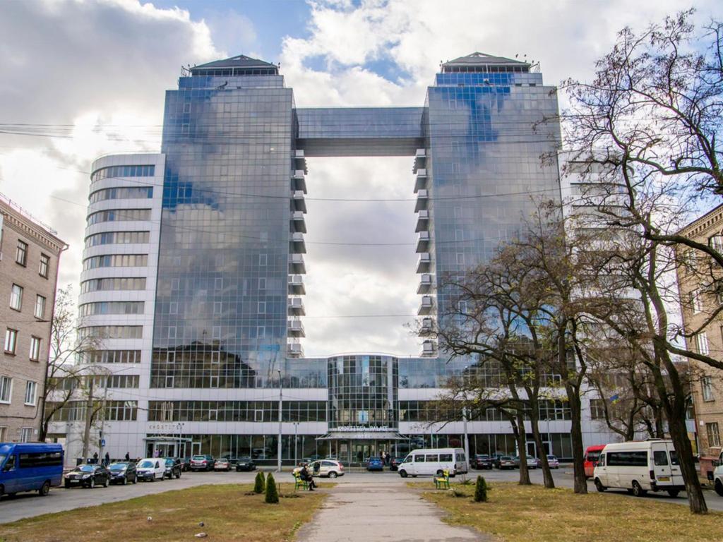 un grand bâtiment avec des fenêtres à miroir dans une ville dans l'établissement Khortitsa Palace Hotel, à Zaporijia