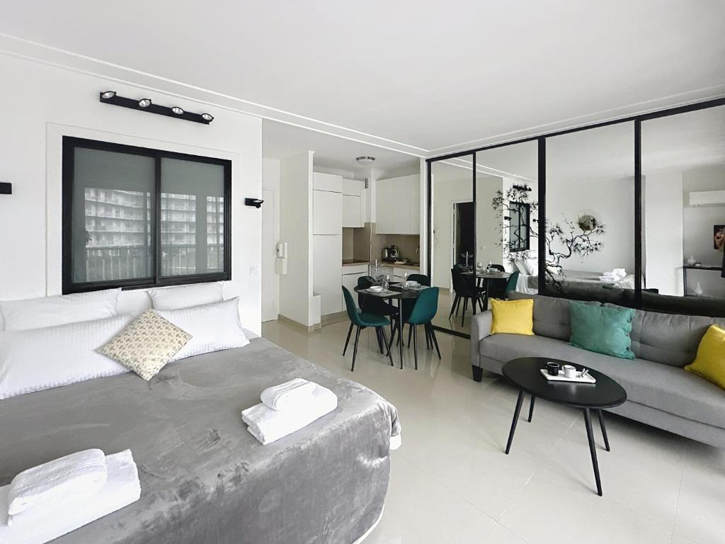 un salon avec un grand lit et un canapé dans l'établissement Studio apartment on La Croisette with terrace, à Cannes