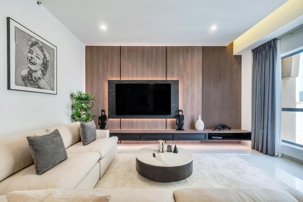 a living room with a couch and a tv at Luxurious Brand New 2BR Apartment in Rimal 1 I Steps to the JBR Beach I GYL Holiday Homes in Dubai