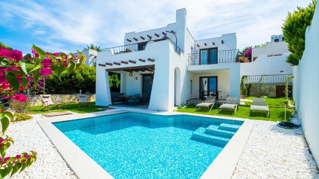 a villa with a swimming pool in front of a house at Villa Greta in Bodrum City