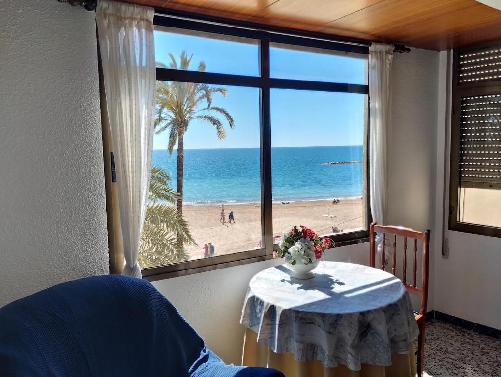 a room with a table and a view of the beach at Primera linea playa in Vinarós