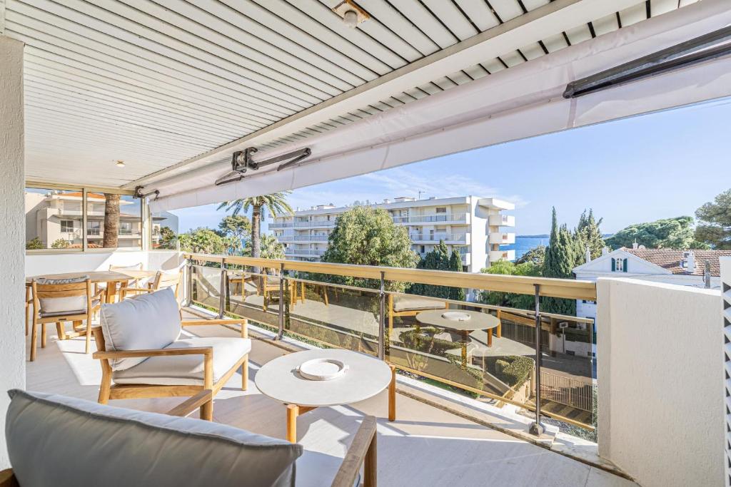 un balcon avec des chaises et des tables sur un immeuble dans l'établissement REF 1980 - Cannes palm Beach sea view, à Cannes