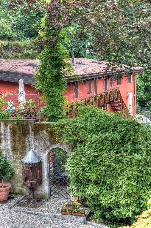 a red house with a building in the background at Villetta La Foresteria in Fondotoce