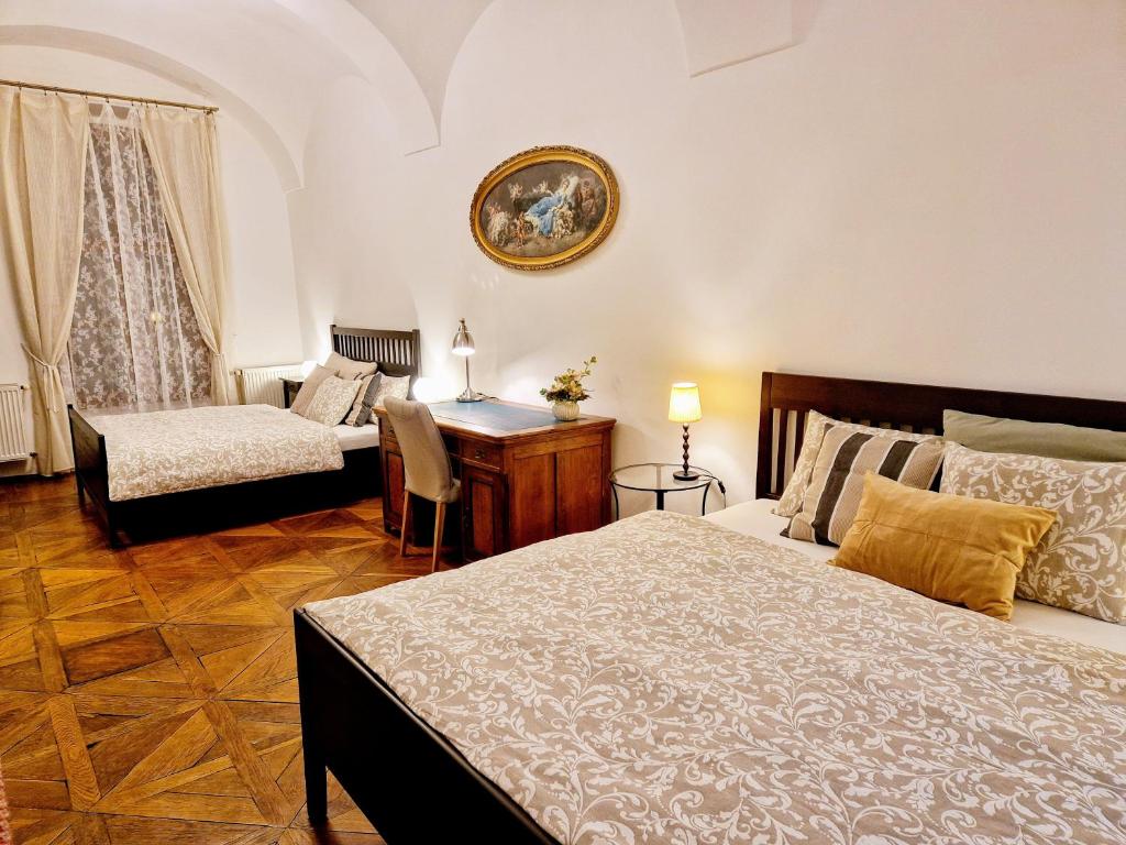 a bedroom with a bed and a desk and a table at Marina Old Town Apartment with 1 free parking offsite in Košice