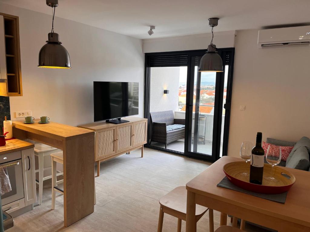 a kitchen and living room with a table and a tv at Apartment Nona Celina in Zadar