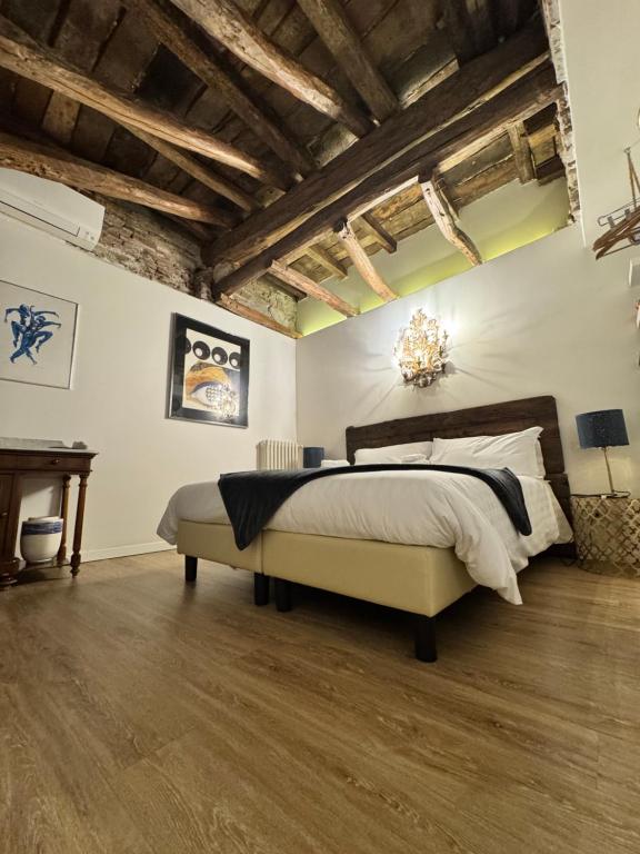 a bedroom with a large bed and a wooden ceiling at L'8 Boutique Concept Apartments in Bologna