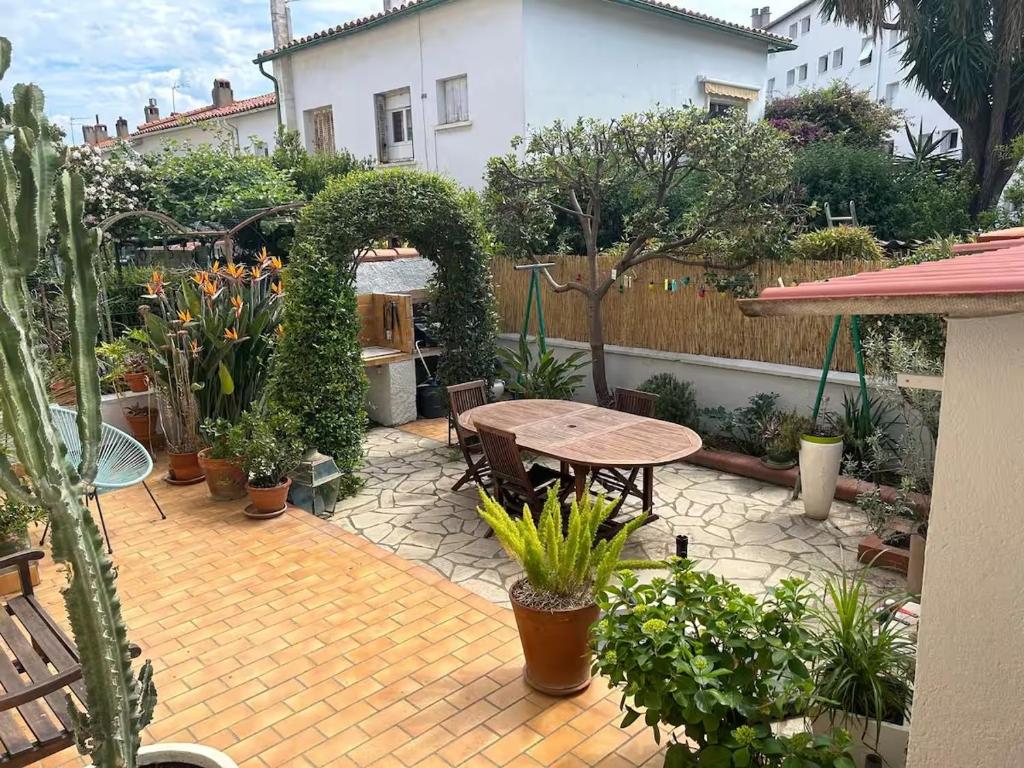 a patio with a table and a bunch of plants at Appartement de 45 m2 dans maison individuel in Perpignan
