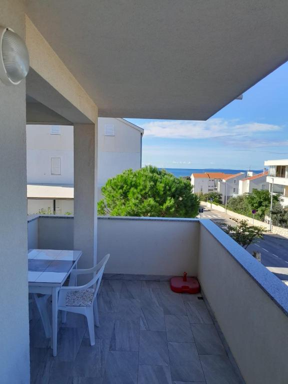 a balcony with a table and a view of the ocean at Apartman Novalja - Put Lokvice in Novalja