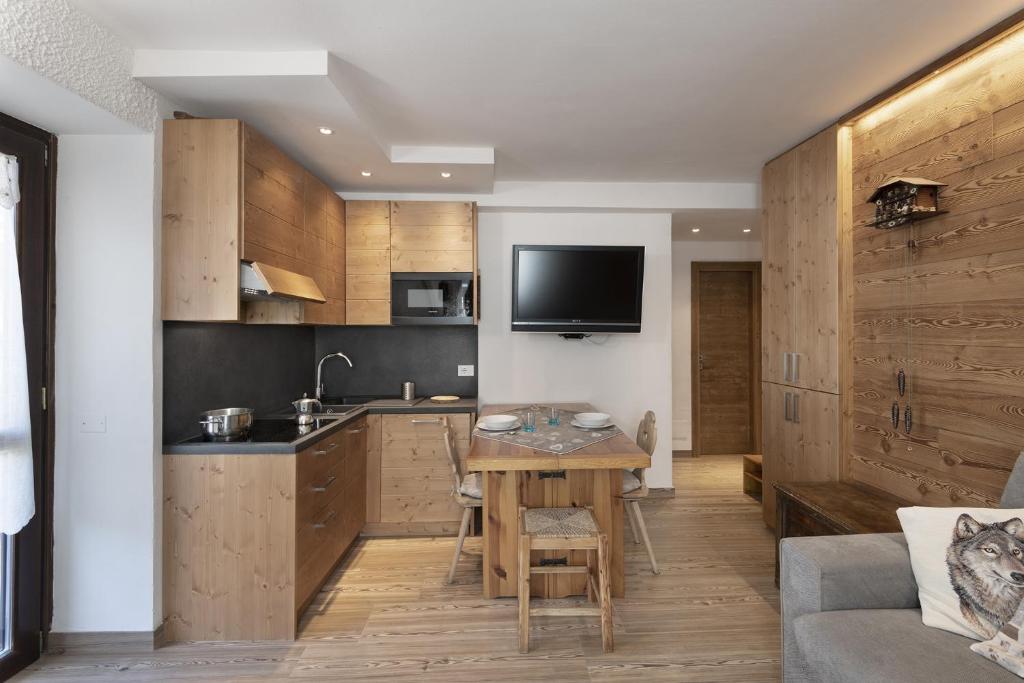 eine Küche mit Holzschränken und einem Tisch in einem Zimmer in der Unterkunft Chalet Diamond - AffittiPontediLegno in Ponte di Legno