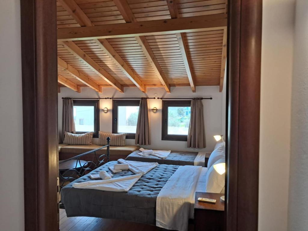 een slaapkamer met twee bedden en twee ramen bij Koxylia apts in Mochlos