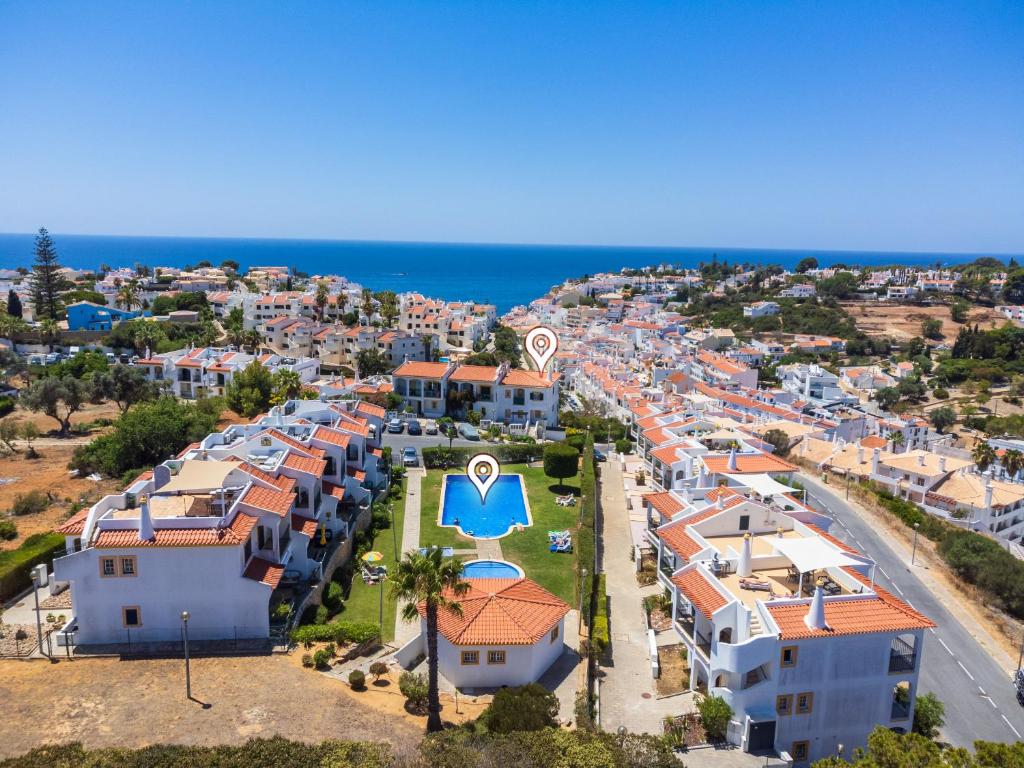 ariale Aussicht auf eine Stadt mit Häusern und das Meer in der Unterkunft Colina Verde G - Charming 1-Bedroom Townhouse in Carvoeiro