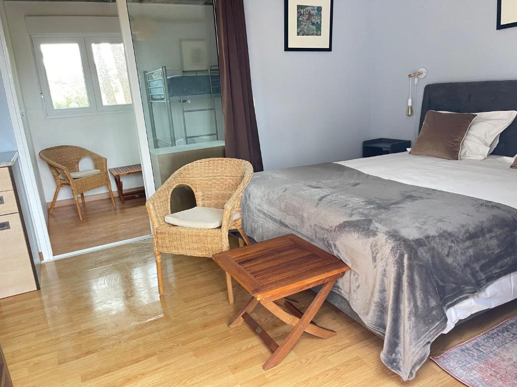 a bedroom with a bed and a table and a chair at Quinta Dos Amarelos no Meco in Aldeia do Meco