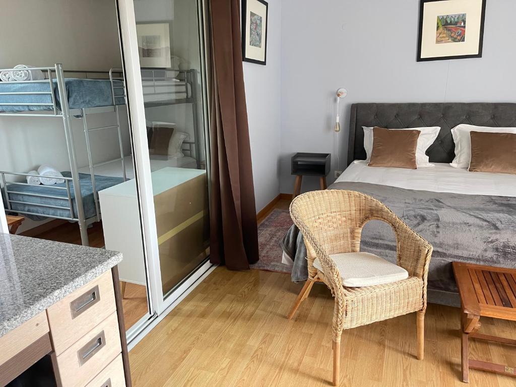 a bedroom with a bed and a chair and a table at Quinta Dos Amarelos no Meco in Aldeia do Meco