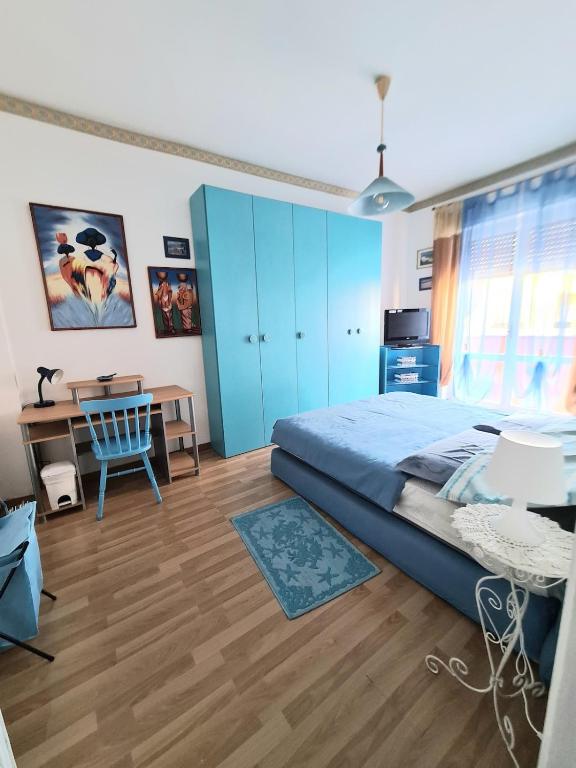 a bedroom with blue cabinets and a desk and a bed at Casa vacanze zona mare in Quartu SantʼElena
