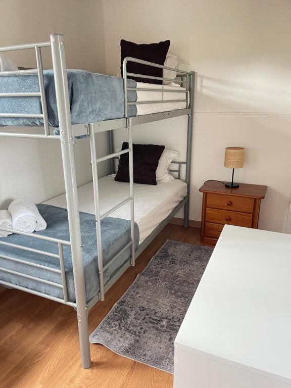 a room with two bunk beds and a table at Quinta Dos Amarelos no Meco in Aldeia do Meco