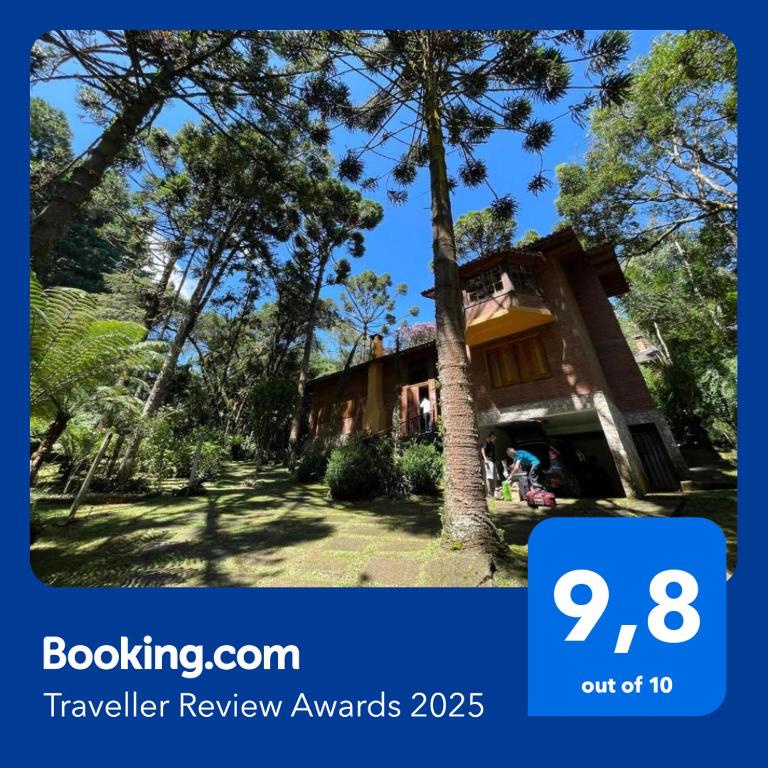 a house with a tree in front of it at CASA EM MONTE VERDE CHARME E CONFORTO in Monte Verde