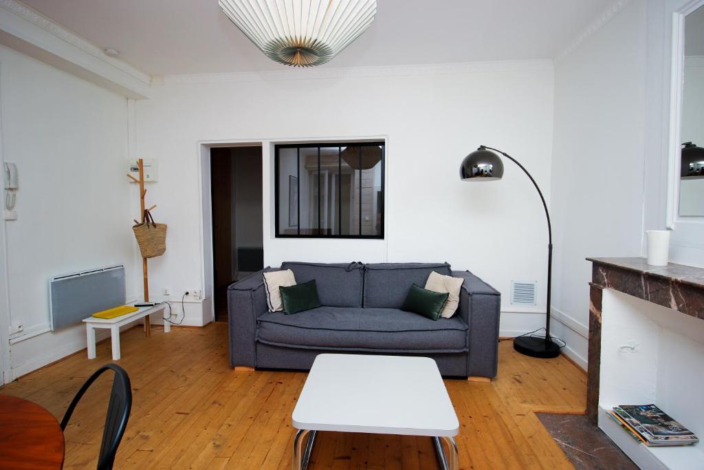 un salon avec un canapé et une table dans l'établissement La Terrasse hyper centre près des Halles, à La Rochelle