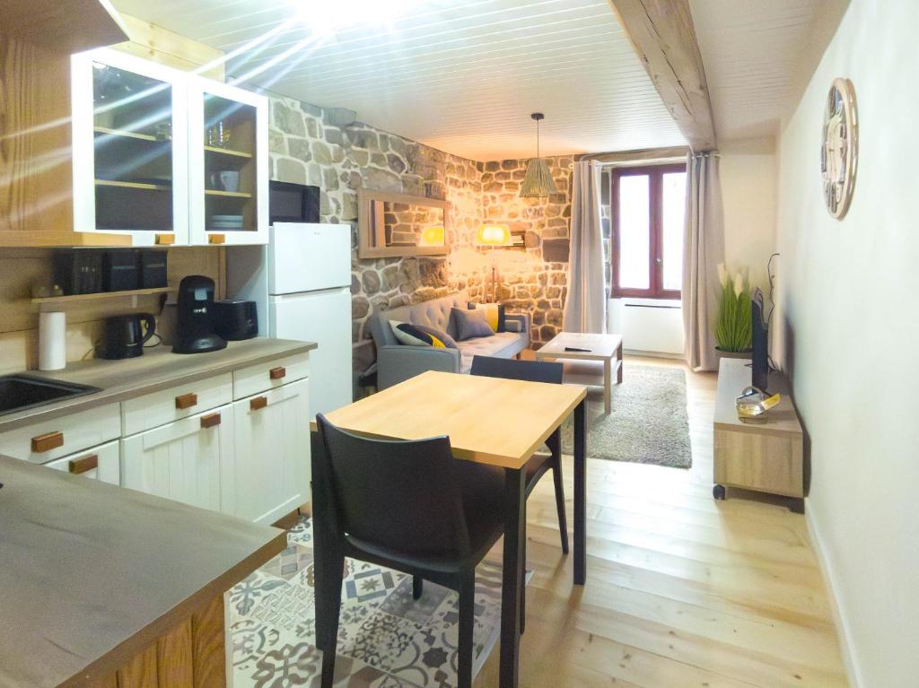une cuisine et un salon avec une table et un canapé dans l'établissement Appartement 35m2, à Montpezat-sous-Bauzon