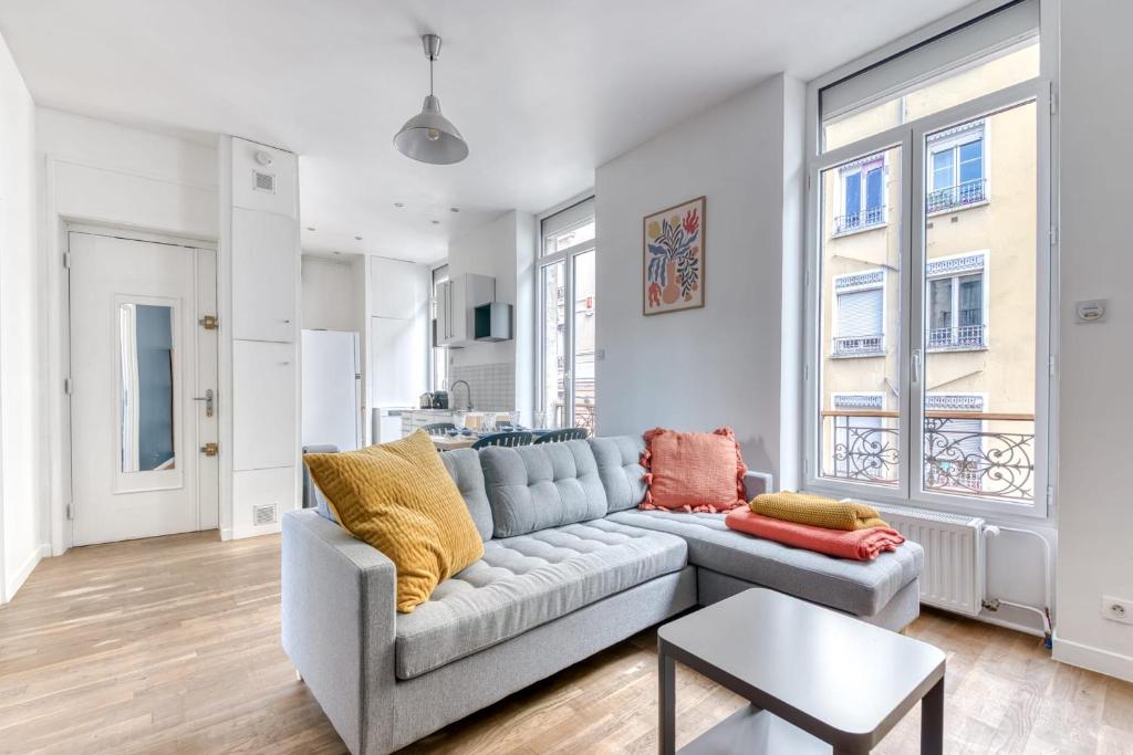 un salon avec un canapé et une table dans l'établissement Appartement Antonin - Welkeys, à Villeurbanne