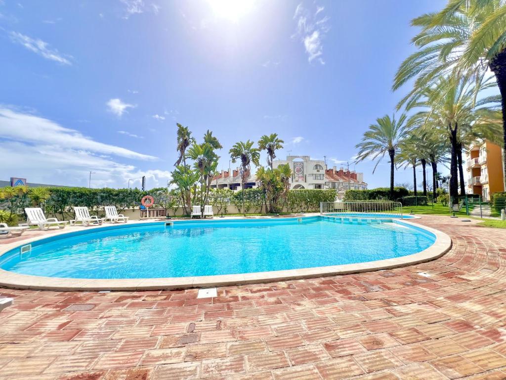 een zwembad in een resort met palmbomen bij Albufeira Modern 6 With Pool by Homing in Vale de Pedras