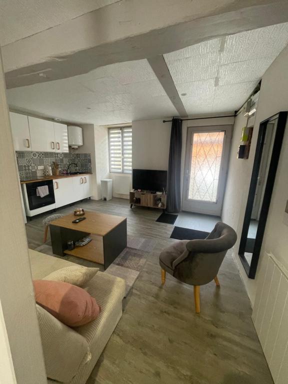 a living room with a couch and a table at Petite maison de ville in Sainte-Maure-de-Touraine