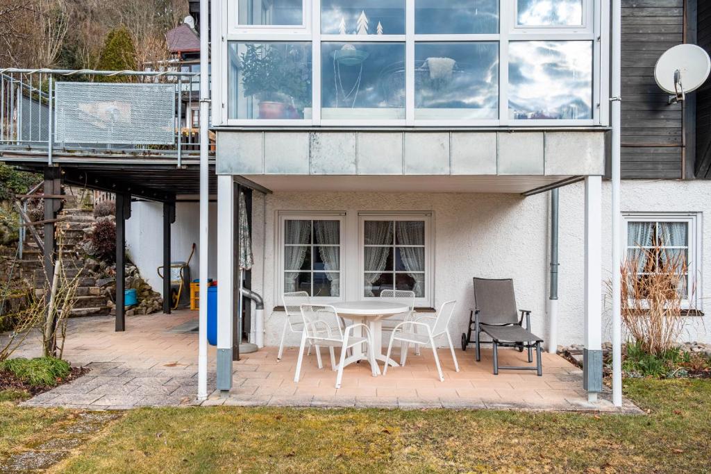 a patio with a table and chairs in front of a building at Haus Aretz in Feldberg